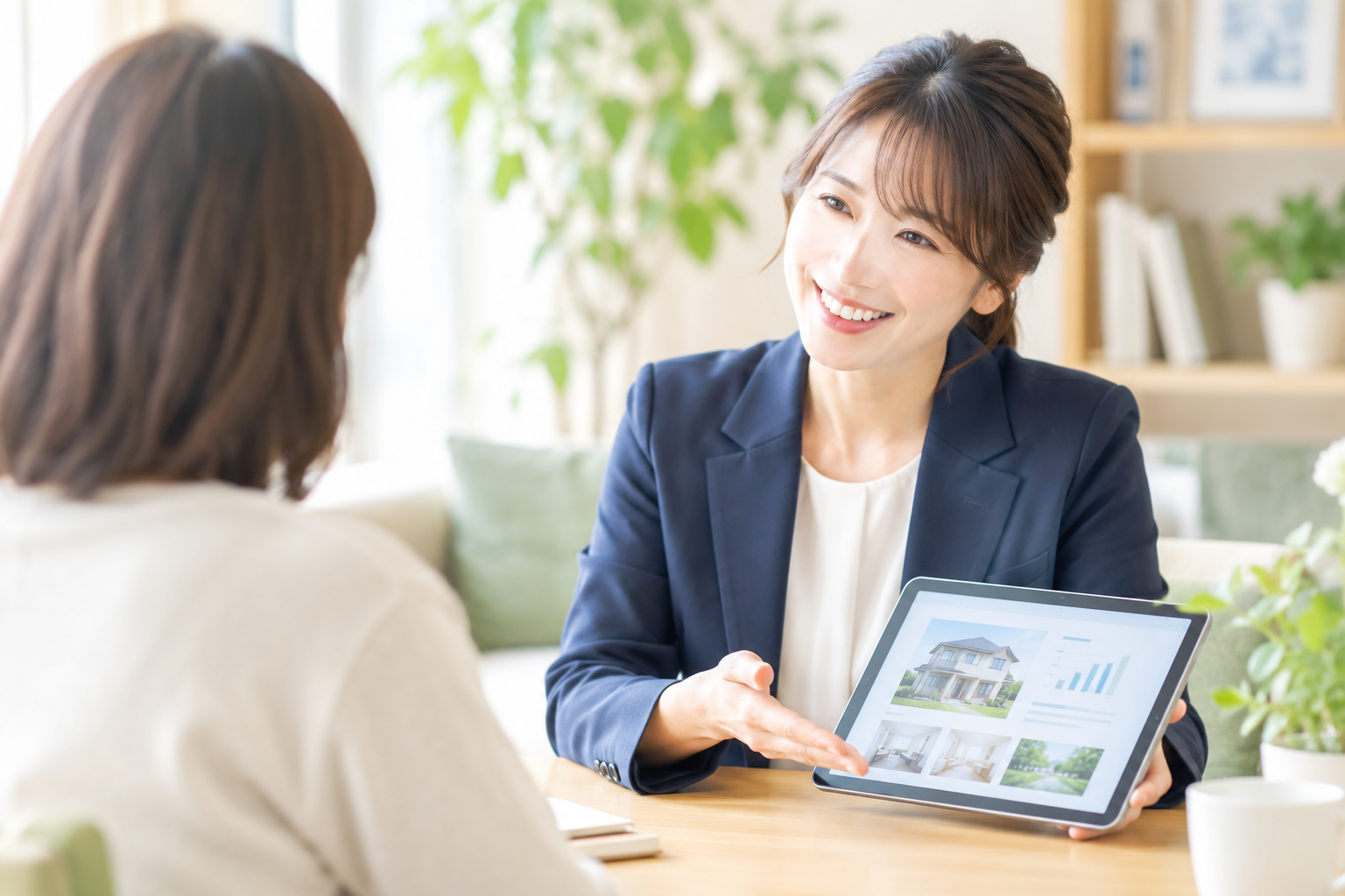 ネイビーのジャケットの女性アドバイザーがタブレットを見せながら相談者に説明している様子