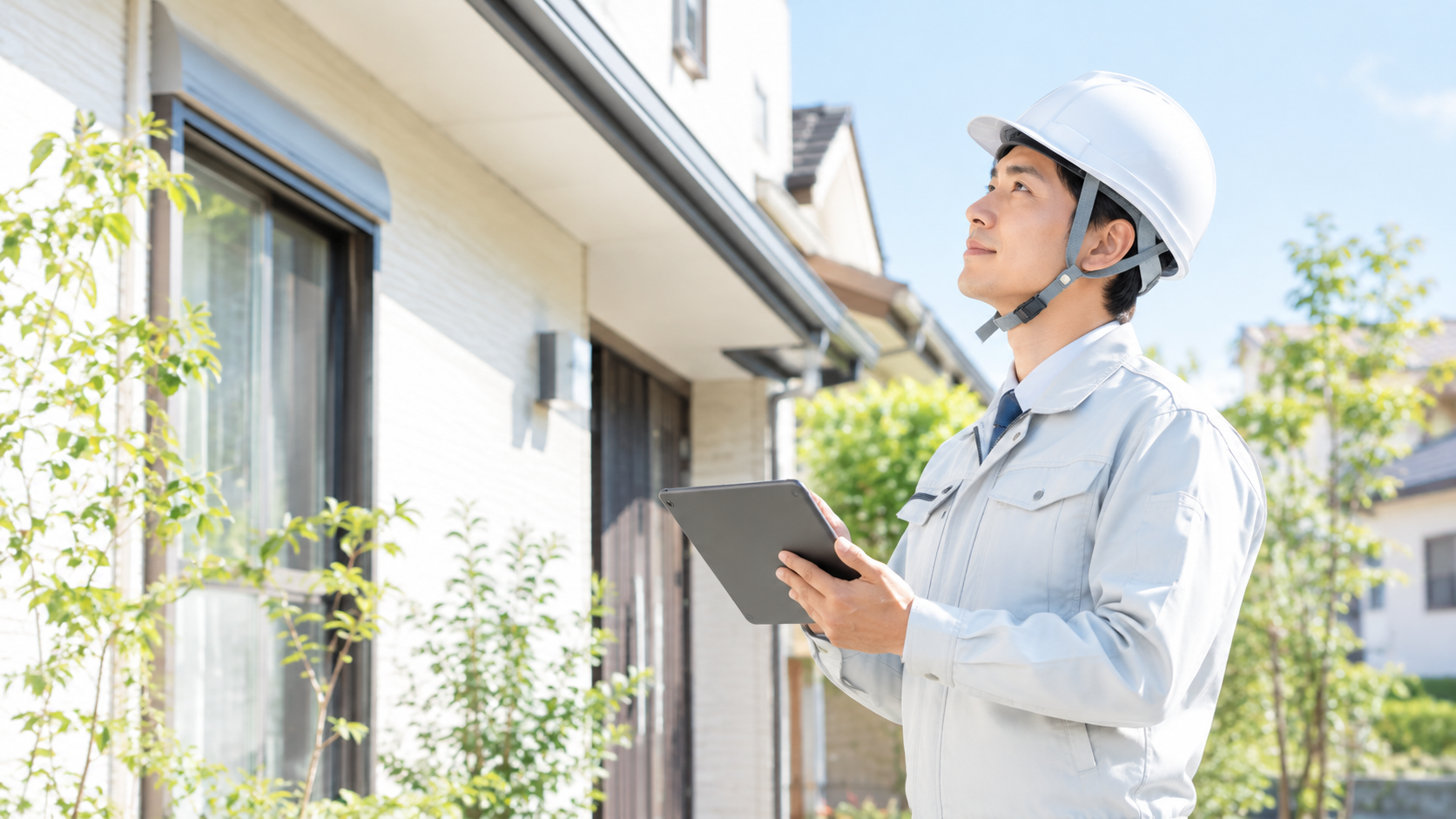 タブレットで住宅を点検する調査員