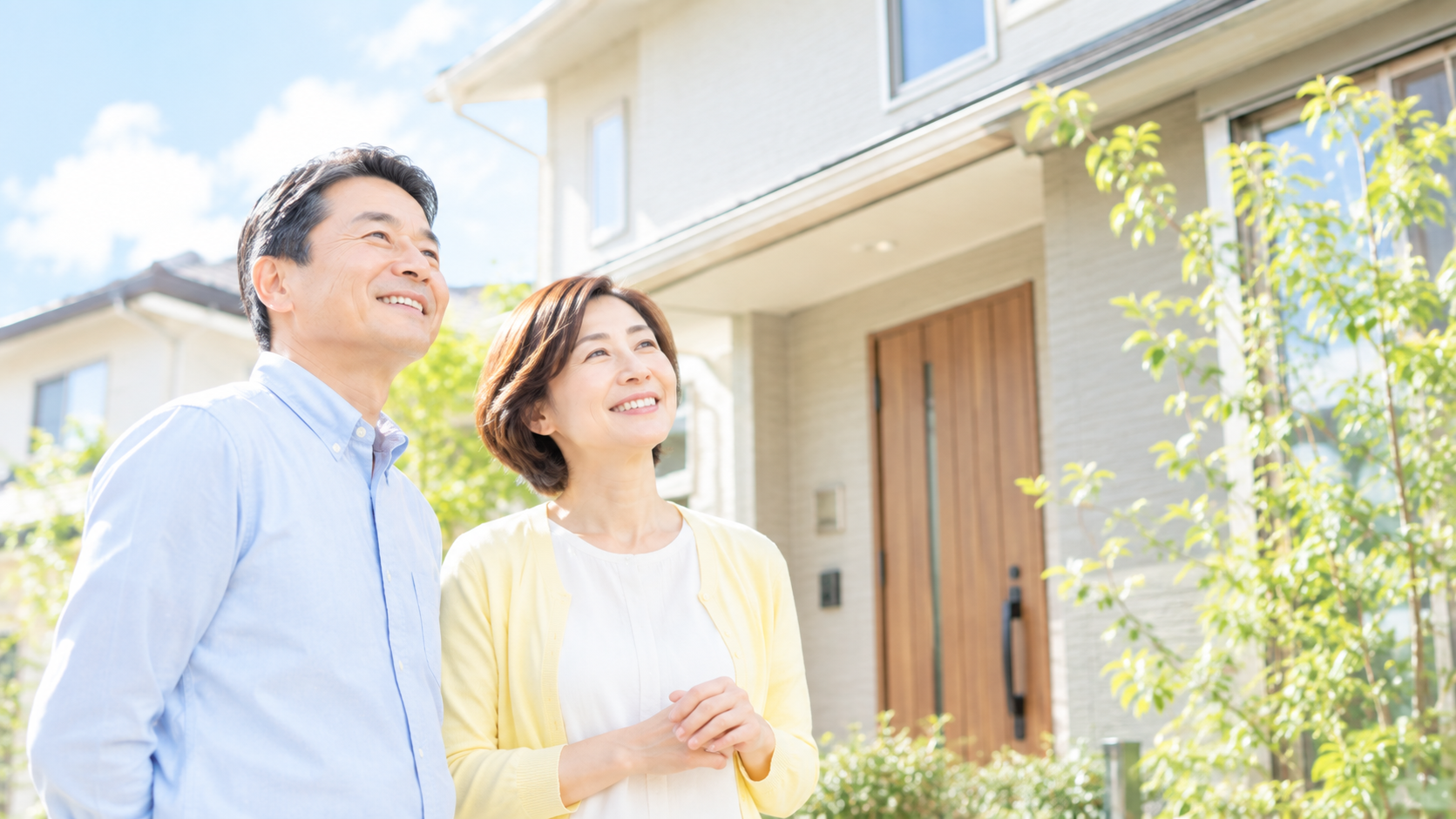 住宅の前で微笑むご夫婦